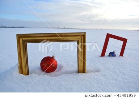 Two  frame and Christmas baubles on snow on field 43491959