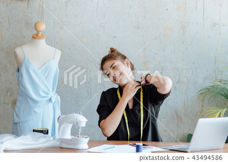 Young designer stretching herself while work 43494586