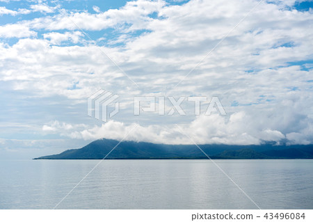 Serene Still Ocean With Mountains In The Distance  43496084