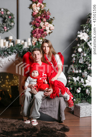 Loving family Merry Christmas and Happy New Year. Cheerful pretty people. Mom, dad and little baby Loving family Merry Christmas and Happy New Year. Cheerful pretty people. Mom, dad and little baby 43501506