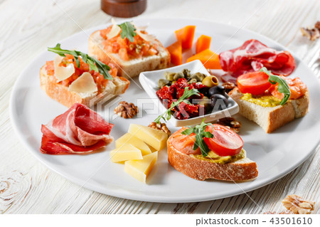 Plate with Italian appetizers. Bruschetta with a cherry tomatoes and shrimps. Parmesan cheese 43501610