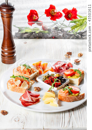 Plate with Italian appetizers. Bruschetta with a cherry tomatoes and shrimps. Parmesan cheese 43501611