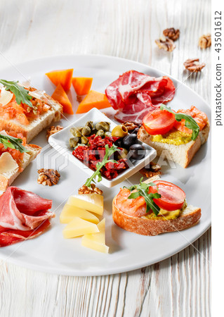 Plate with Italian appetizers. Bruschetta with a cherry tomatoes and shrimps. Parmesan cheese 43501612