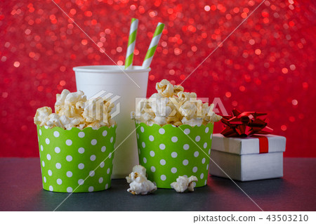 popcorn and drink in paper cup for movie and entertainment, a present, red bokeh background 43503210