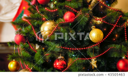 Christmas closeup background with colorful baubles and garlands hanging on Christmas tree 43505463