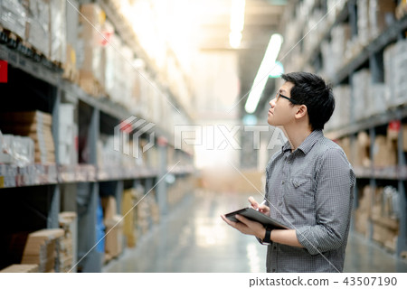 Asian man doing stocktaking on tablet in warehouse 43507190