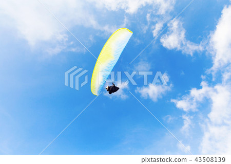 Man with yellow parachute over blue sky 43508139