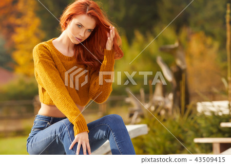 woman is sitting on the terrace in front of the house. Autumn sc woman is sitting on the terrace in front of the house. Autumn sc 43509415