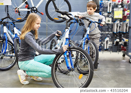 Girl and boy choose bicycle in sports supermarket 43510204