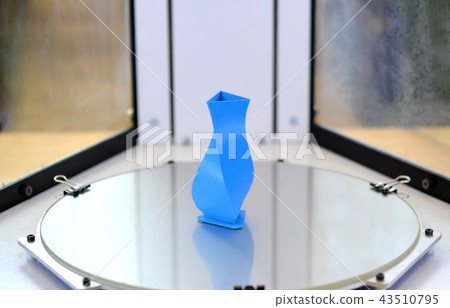 Bright blue object printed by 3d printer on 3d printer inside. Bright blue object printed by 3d printer on 3d printer inside. 43510795