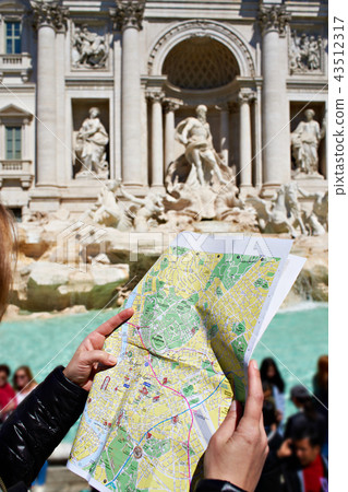Map of Rome in hands tourist and Trevi Fountain 43512317