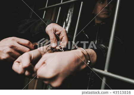 Man In Handcuffs Behind Bars In A Police Station. Man In Handcuffs Behind Bars In A Police Station. 43513816