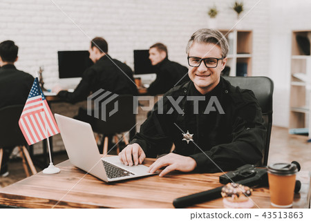 Policeman Works On Laptop In A Police Station. Policeman Works On Laptop In A Police Station. 43513863
