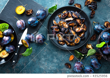 Dried prune and fresh plums with leaves 43525956