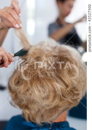 Hands of hairdresser making hairstyle for female Hands of hairdresser making hairstyle for female 43527300