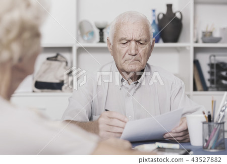 Upset senior man discussing with wife bills Upset senior man discussing with wife bills 43527882