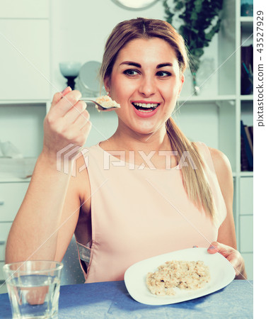 Sporty girl is enjoying breakfast with oatmeal porridge 43527929