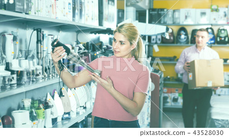 Young woman customer is looking new blender in appliances store Young woman customer is looking new blender in appliances store 43528030