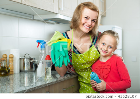 Little girl and mom tidy up at kitchen. 43528107