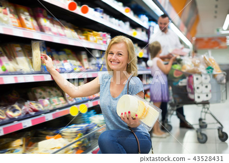 Cheerful female customer selecting cheese 43528431