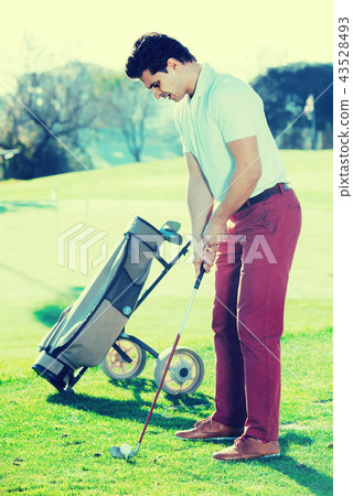 Man playing golf is going to hit ball at golf course 43528493