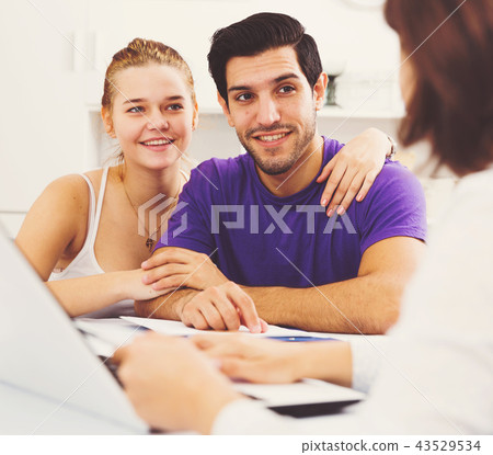 Young couple with real estate agent at home 43529534