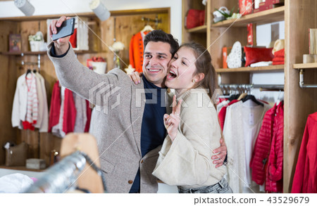 Young woman and man are taking selfie after shopping together Young woman and man are taking selfie after shopping together 43529679