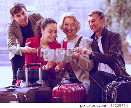 Tourists with map and baggage in city. Tourists with map and baggage in city. 43529724