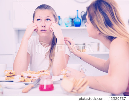 Female talking with young sad friend at home 43529787