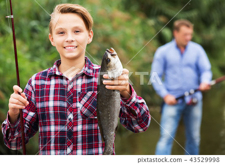 Fisher boy showing catch fish 43529998