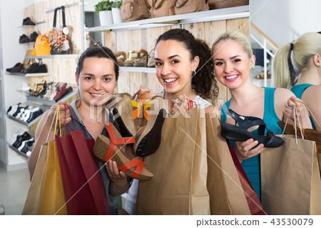 Three women choosing shoes in the store. 43530079