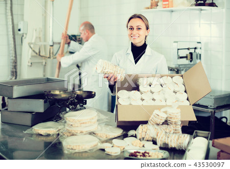 Different aged couple standing with box of turron in production workshop Different aged couple standing with box of turron in production workshop 43530097