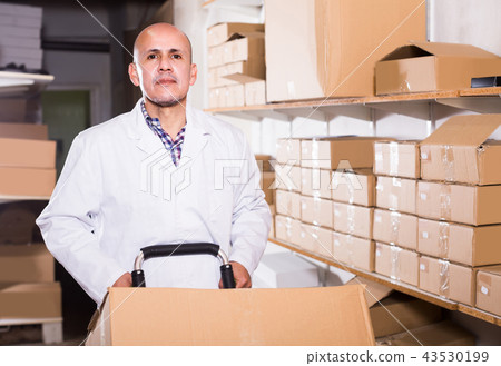 Portrait of mature male with carton boxes in warehouse Portrait of mature male with carton boxes in warehouse 43530199