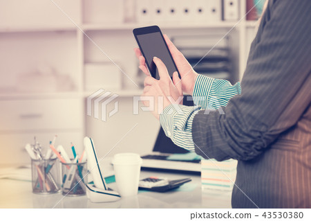 Woman using touchscreen phone Woman using touchscreen phone 43530380