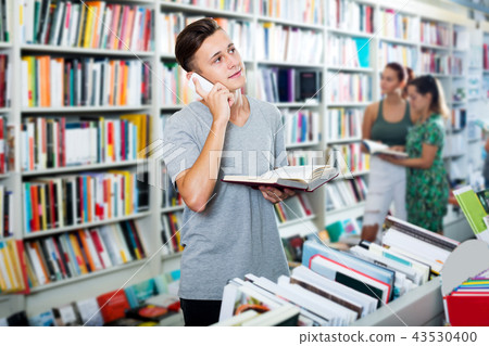 Boy chatting on mobile phone and searching book 43530400