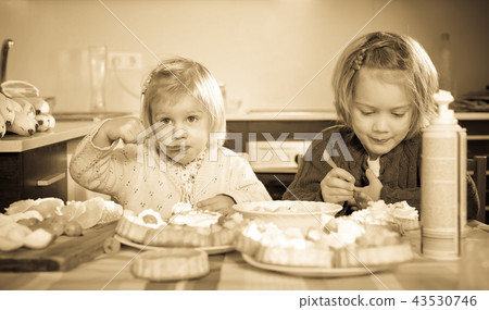 Kids eating pastry indoors 43530746