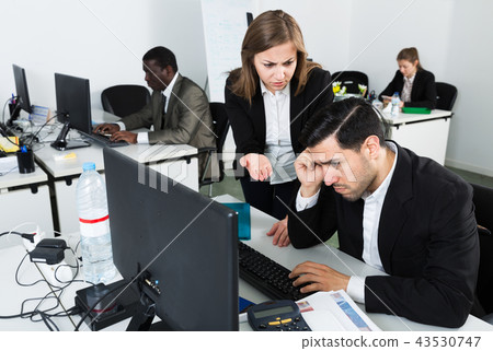Unhappy manager working at laptop Unhappy manager working at laptop 43530747