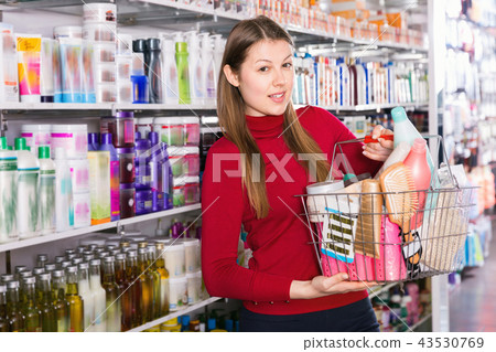 Young woman is standing with purchases in hair care store. Young woman is standing with purchases in hair care store. 43530769
