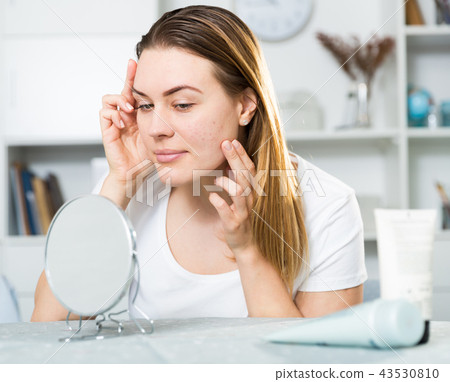 Young woman is satisfied of quality her skin in with mirror 43530810