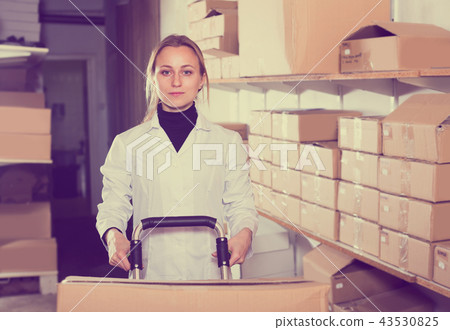 Woman standing in production workshop with boxes 43530825