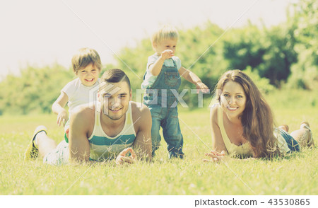 Family of four in grass at park 43530865