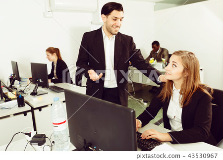 female manager working and man colleague helping female manager working and man colleague helping 43530967