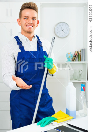 Male professional janitor dusting in office Male professional janitor dusting in office 43531045