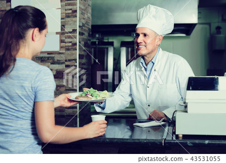 man cook serving fresh kebab dish to customer on counter in fas 43531055