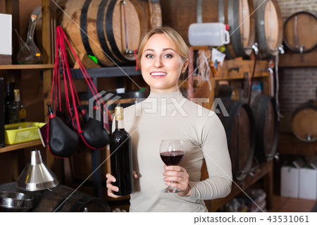 Woman selecting wine in wine house. Woman selecting wine in wine house. 43531061