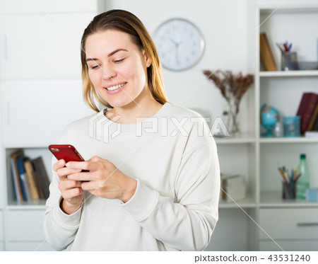 Young woman is resting and smiling with phone Young woman is resting and smiling with phone 43531240