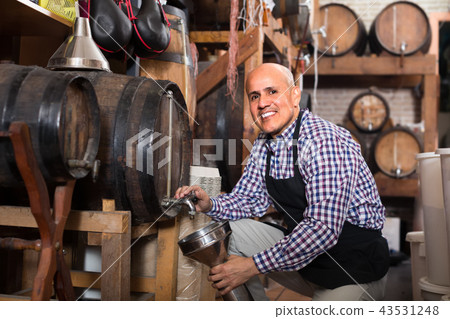 Smiling seller pouring wine from wood Smiling seller pouring wine from wood 43531248