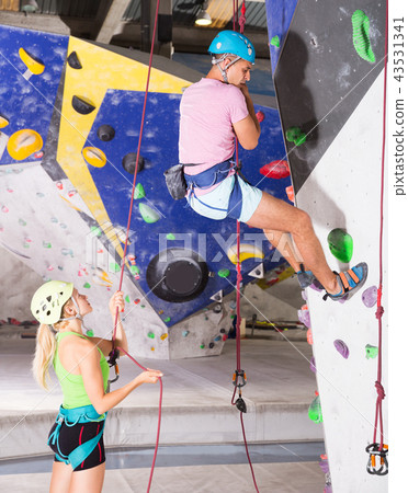 Couple of alpinist practicing in pair indoor rock-climbing 43531341
