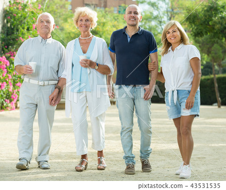 Smiling family of four walking with plastic cups 43531535