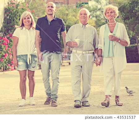 Smiling family of four walking in the garden Smiling family of four walking in the garden 43531537
